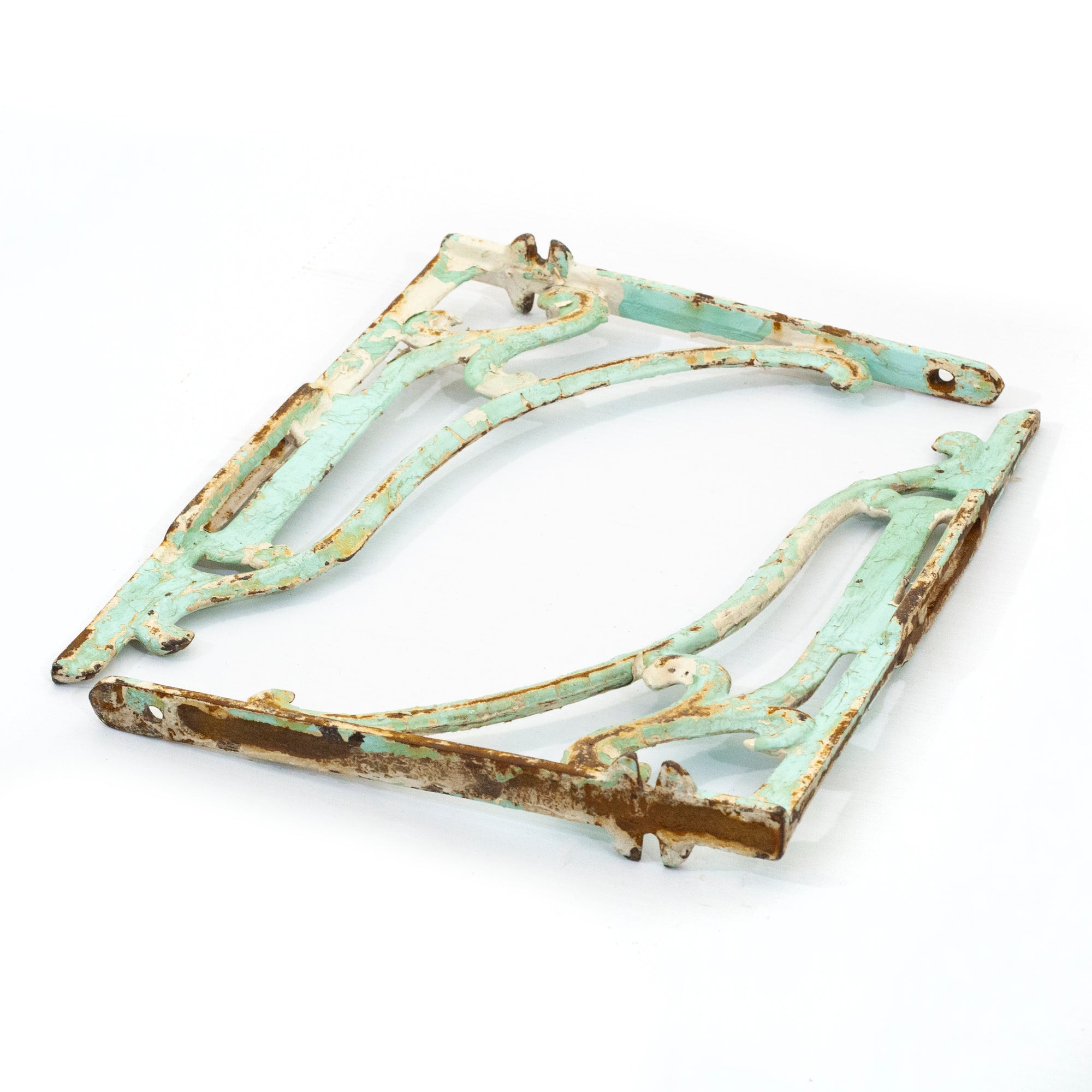 this is a pair of vintage cast iron shelf brackets, they are painted a mint color and have rust on them