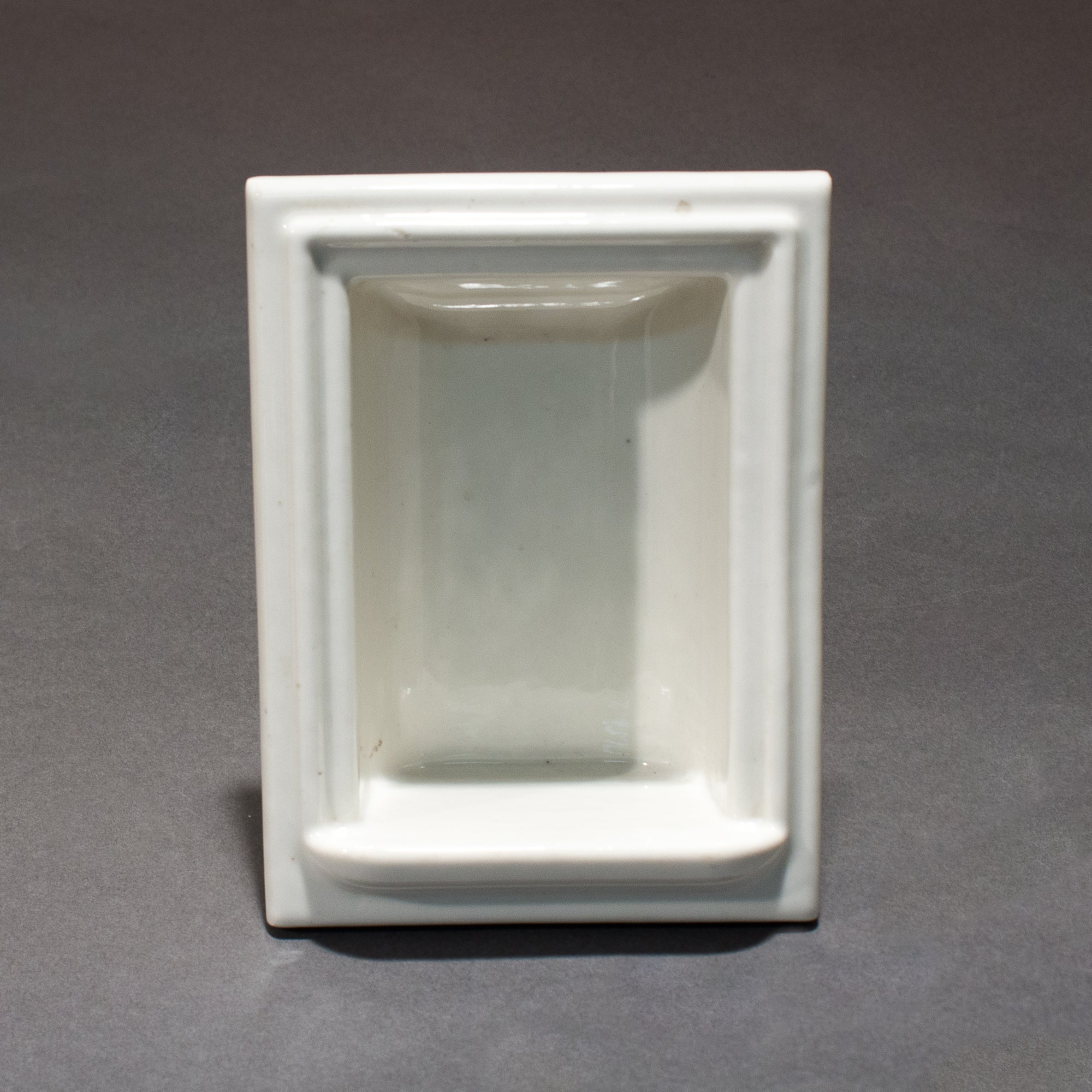 this is an antique vintage white porcelain soap holder for a shower