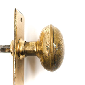 this is a side profile view of the door knob on a bronze door knob set. There is considerable wear on the knob. 