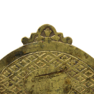 this is an up close picture of an antique brass bail pull showing the detail in the top middle 