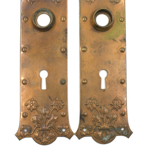 this is an up close picture of the bottom half of a pair of vintage floral copper escutcheons