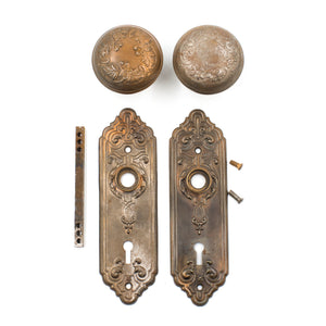 this picture shows all the components of an antique bronze coated corbin door knob set with escutcheons, spindle and set screws