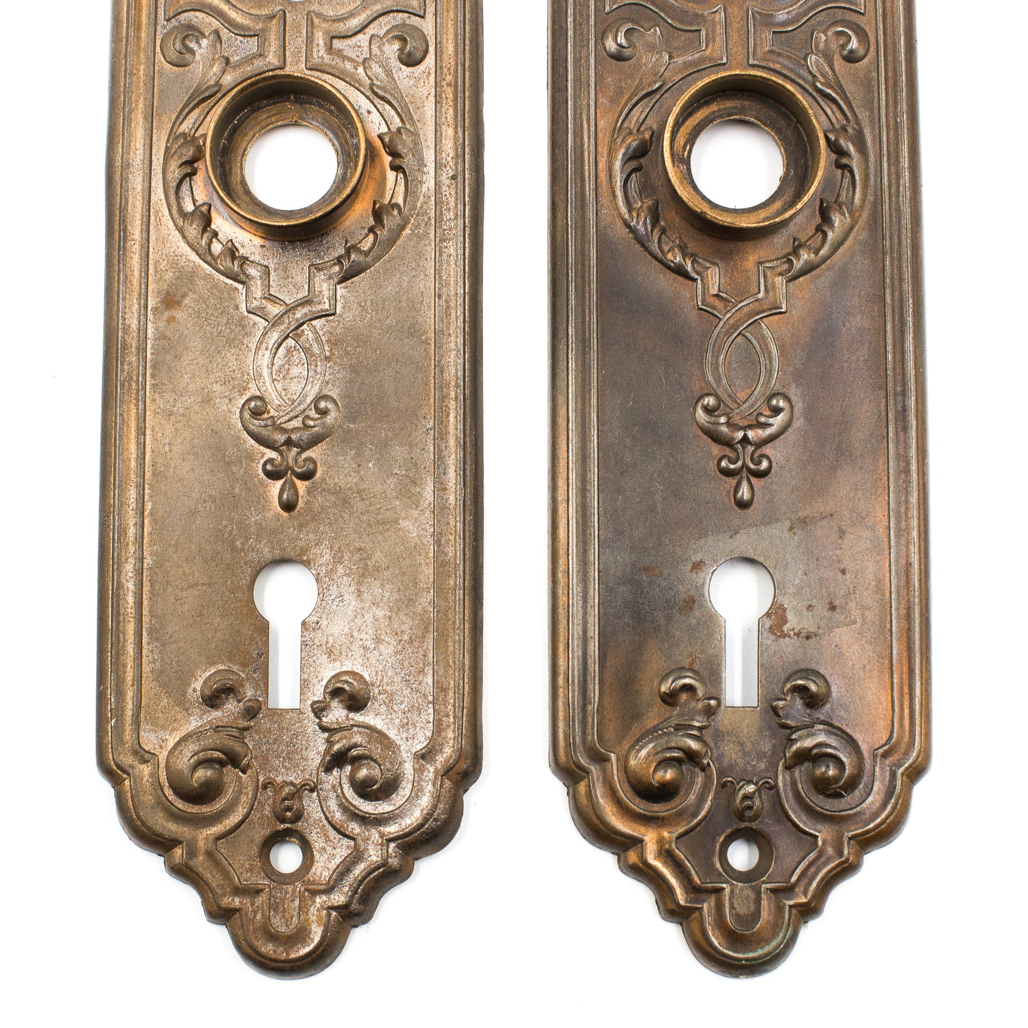 this picture shows the bottom halves of a pair of antique escutcheons